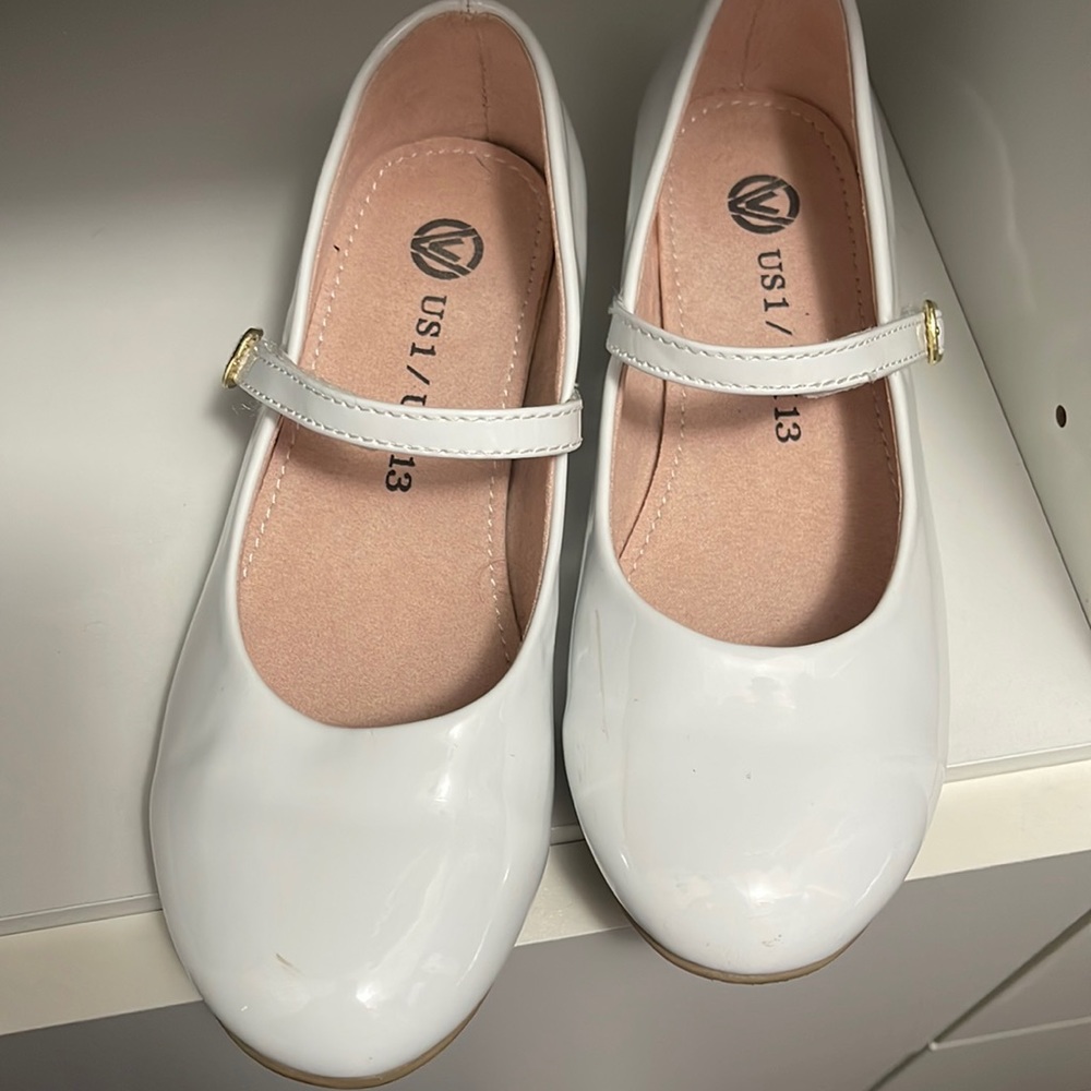 White size 1 girls shoes with small heel.